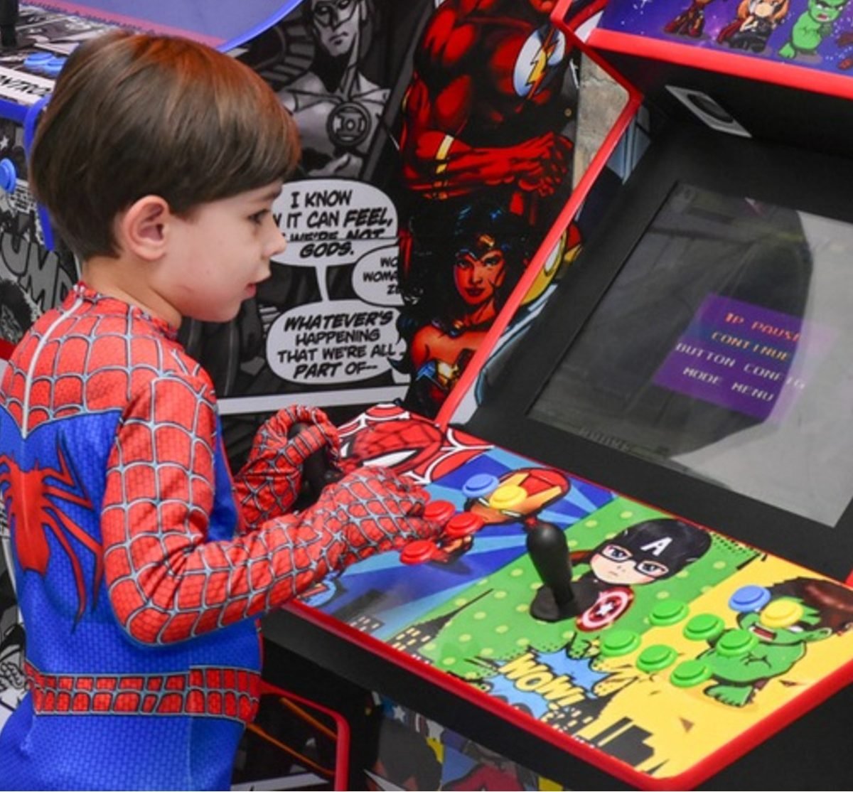 Criança fantasiada jogando no fliperama da Kinder Haus
