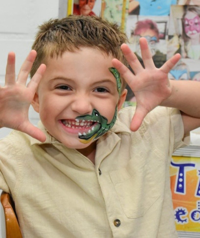Menino com pintura artística no rosto em festa na Kinder Haus